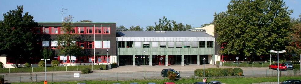 LVR-Helen-Keller-Schule von vorne fotografiert. Im linken Bereich ist Haus 1, in der Mitte des Bildes die Eingangshalle, sowie im rechten Bereich des Bildes ist Haus 2 hinter einem Baum zu sehen.